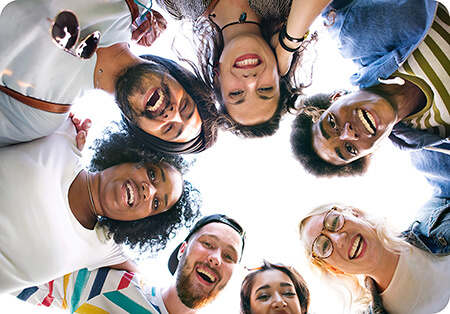 Circle of friends looking below at viewer and smiling