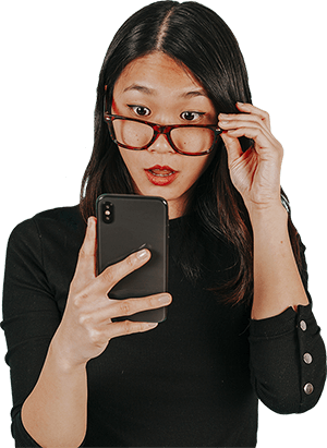 Woman with glasses looking at her smartphone intensely