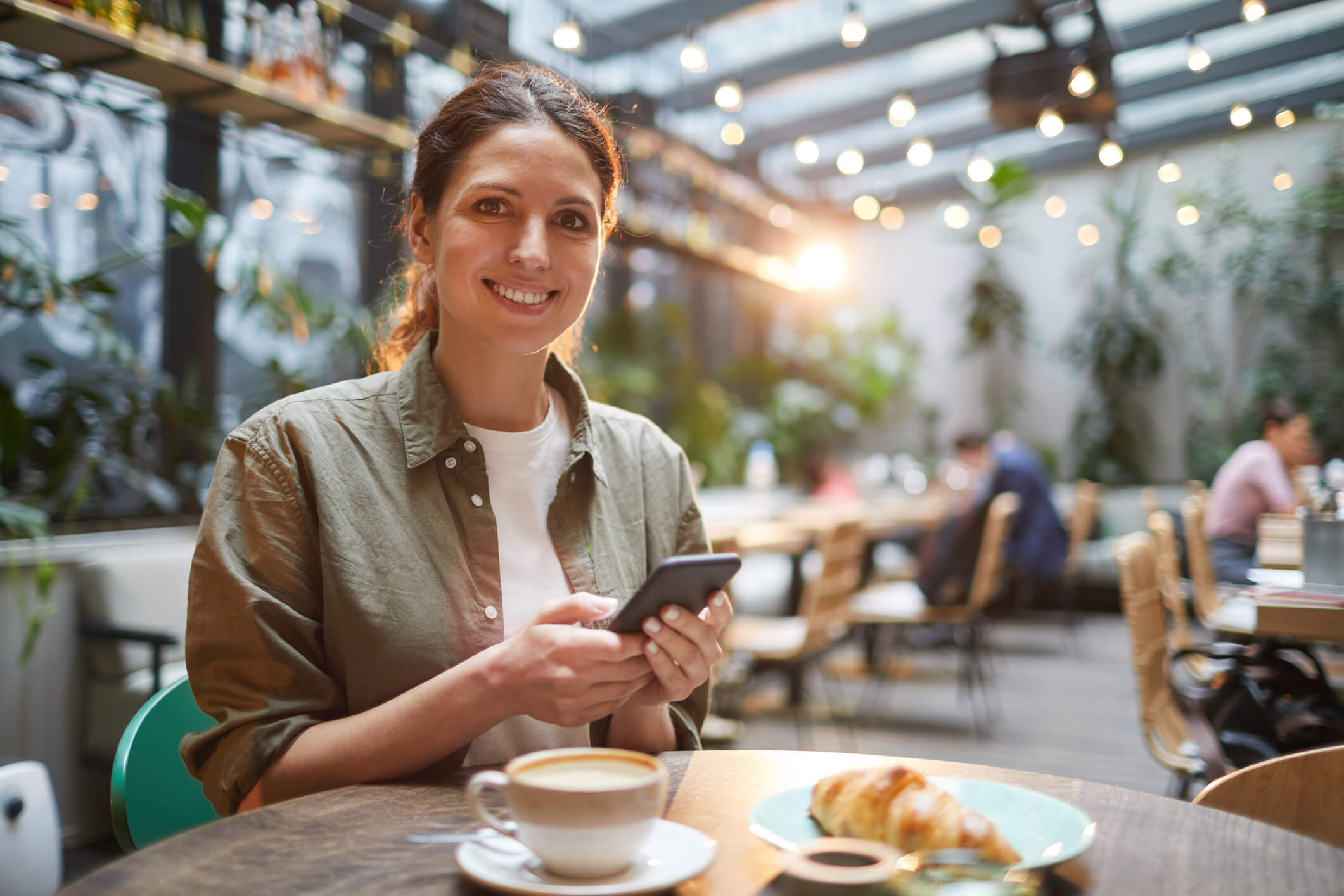 Woman holding a phone smiling